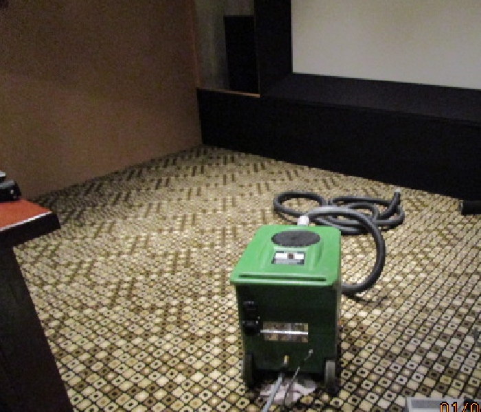 home theater room with carpet and green extraction machine in place