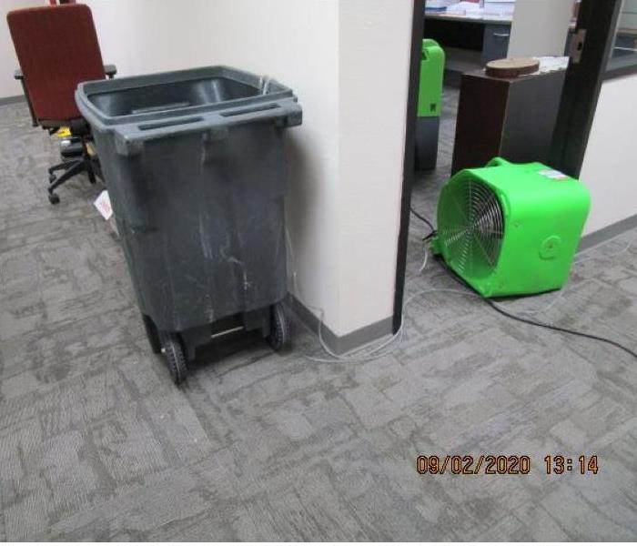Large trash can with hoses from  dehumidifiers going into it